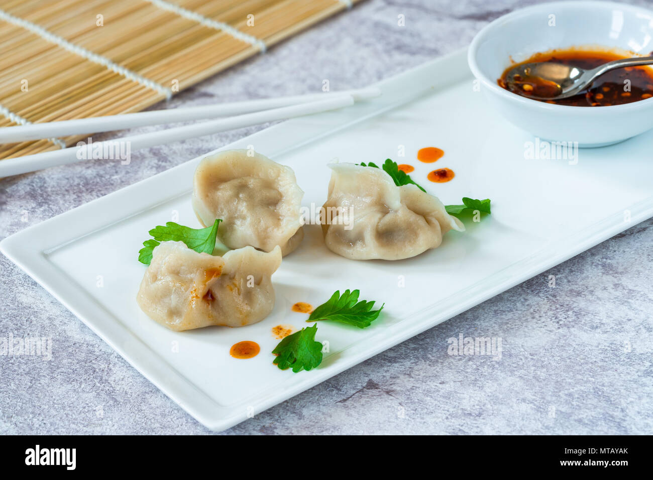 Chinese pork dumplings dim sum with sweet chili dipping sauce Stock