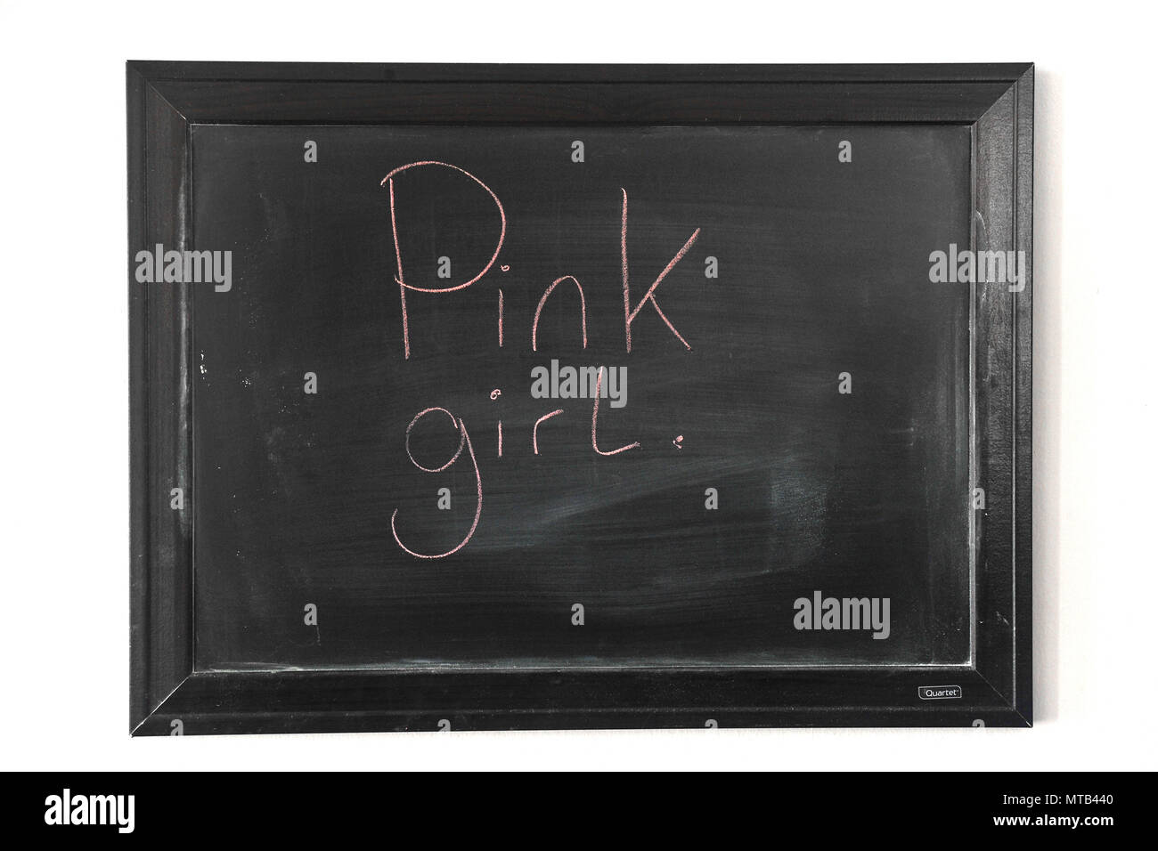 Pink girl written in pink chalk on a wall mounted blackboard Stock Photo