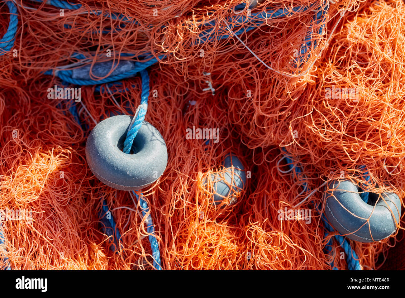 Fishing net with blue rope and buoys on the dock. Close up. Stock Photo