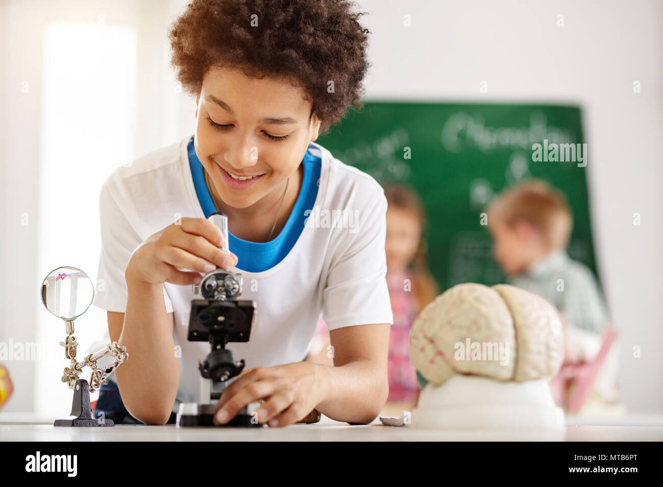 Delighted nice boy using a microscope Stock Photo