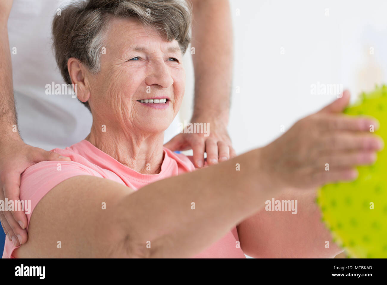 Elderly Woman Enjoying Her Isometric Exercises With A Yellow Spiked