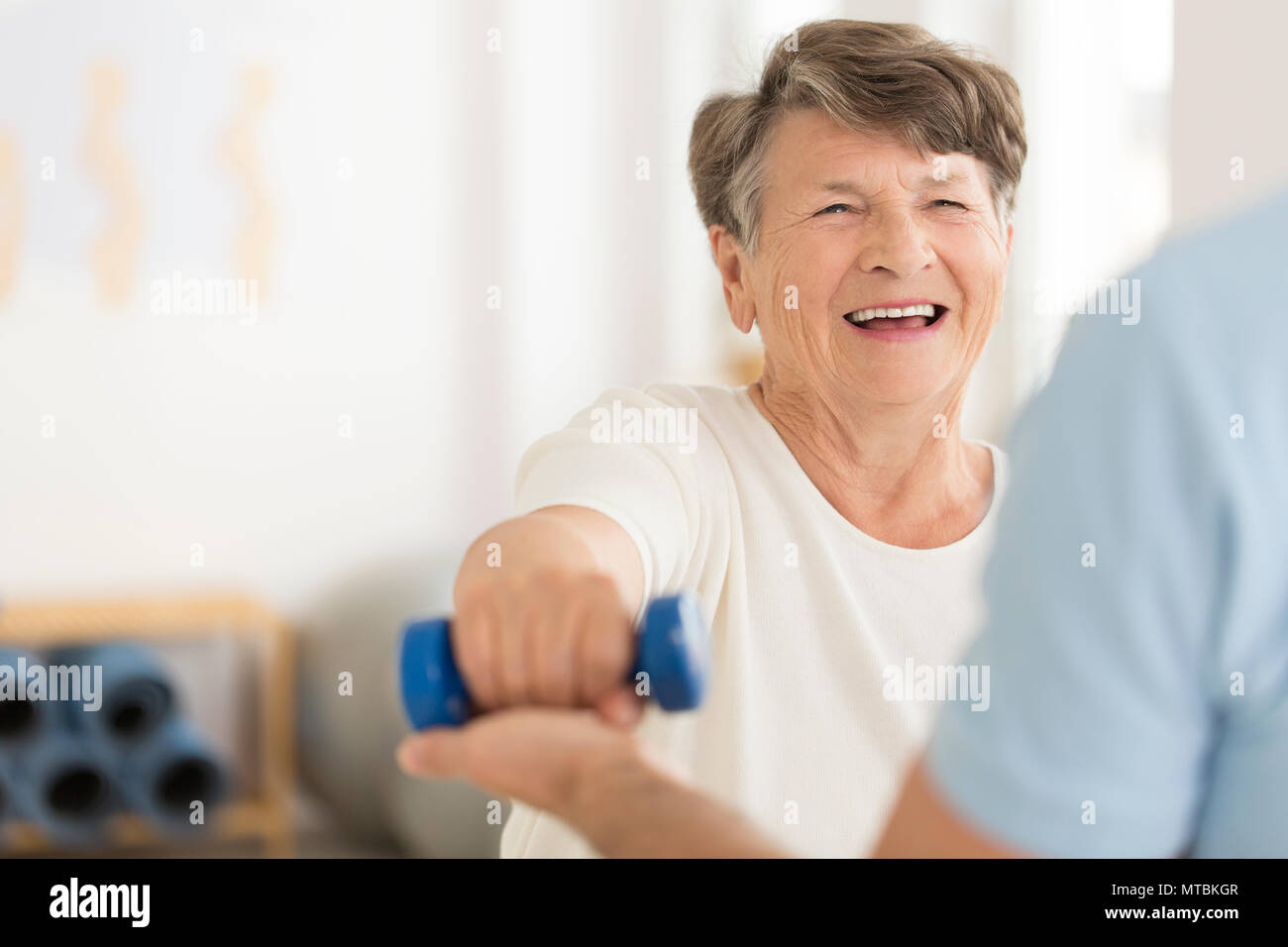 Joint relieving isometric exercises with a blue dumb-bell Stock Photo