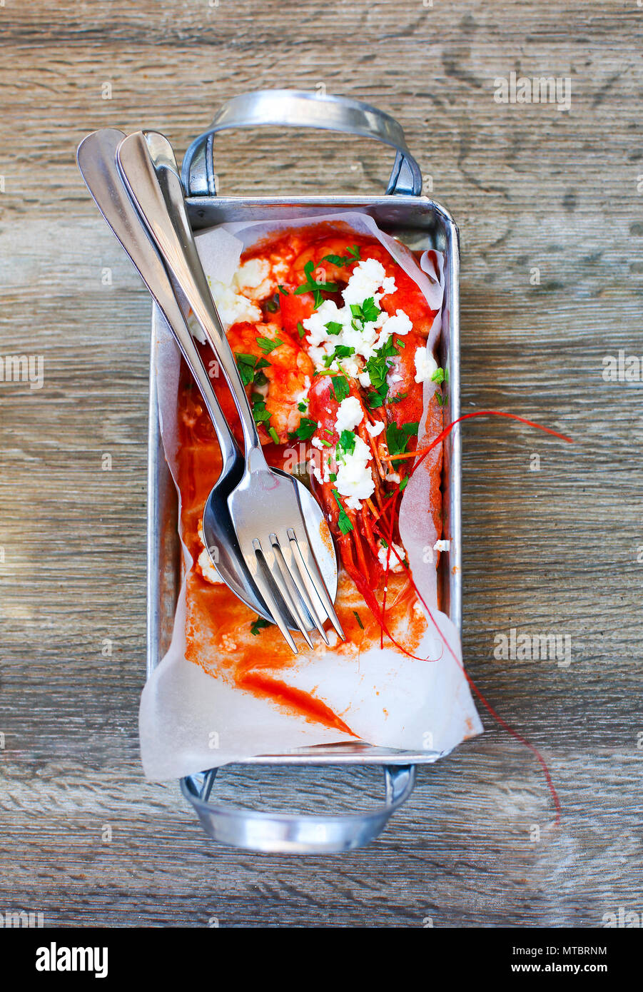 Greek starter shrimp in tomato sauce on wooden background. Top view Stock Photo