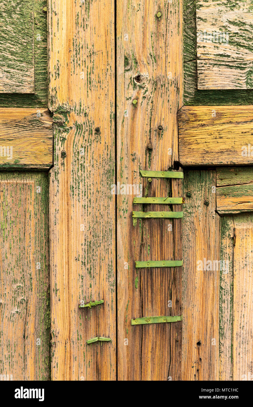 Abstract details of old wooden door with metal fixing, repairs, neglected with peeling paintwork and broken glass, Vilaflor, Canary Islands, Spain, Stock Photo