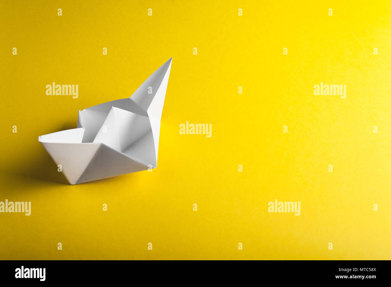 boat paper origami on the yellow background Stock Photo
