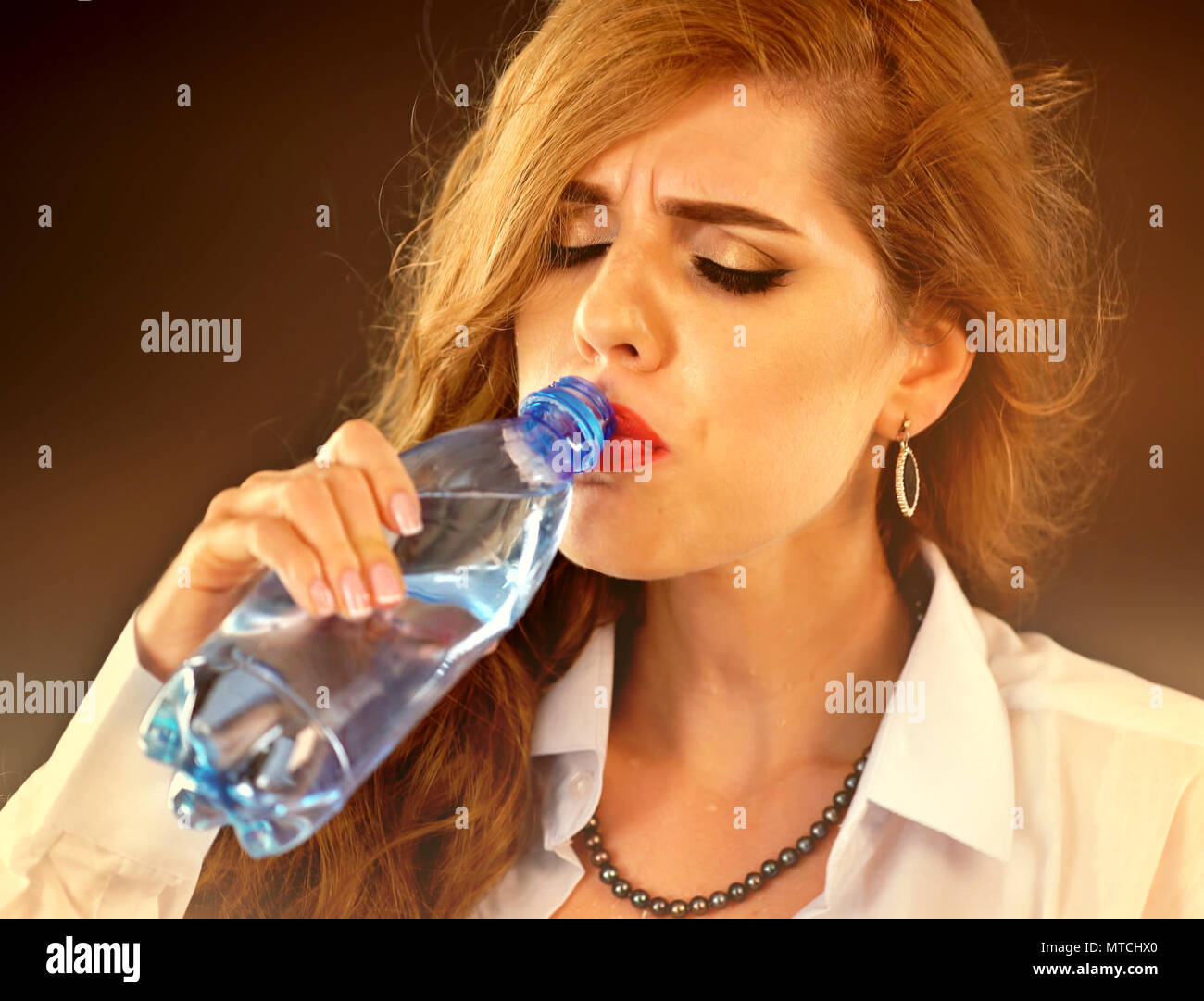 Sensitive teeth woman drinking cold water from bottle. Sudden toothache