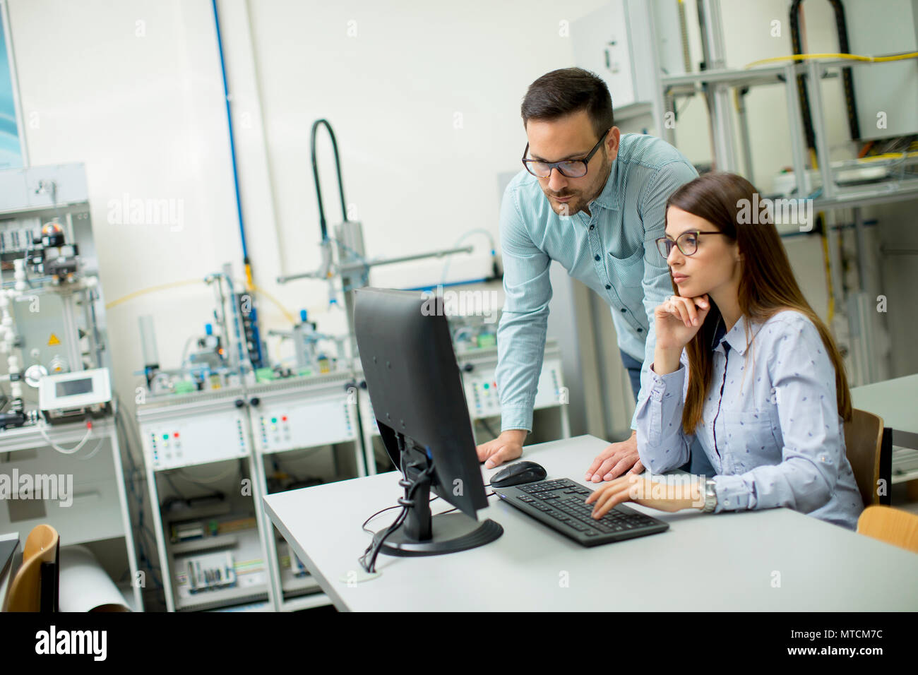 Side view of focused students using desktop pc in classroom at