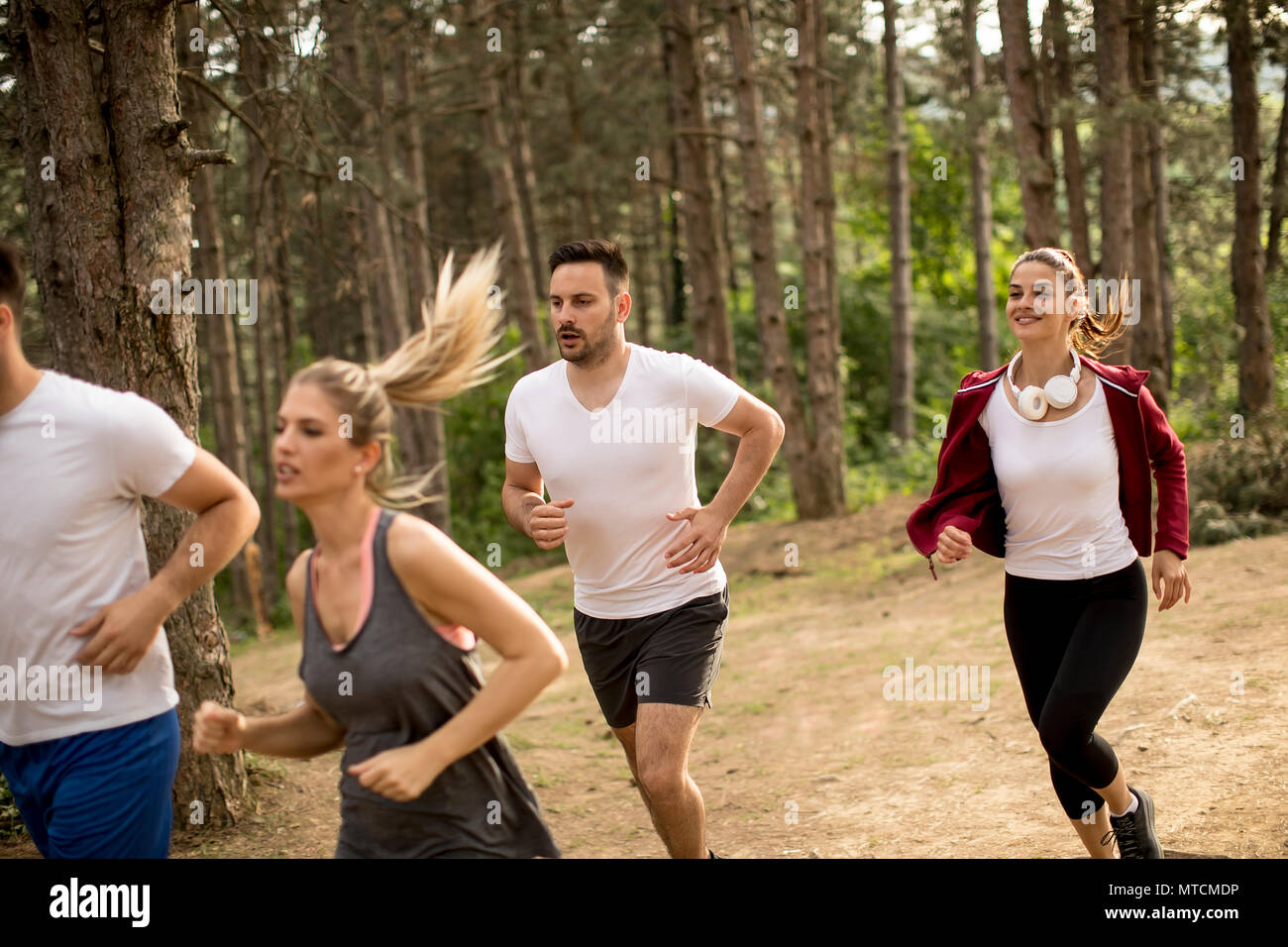 Group of young people run a marathon through the forest Stock Photo