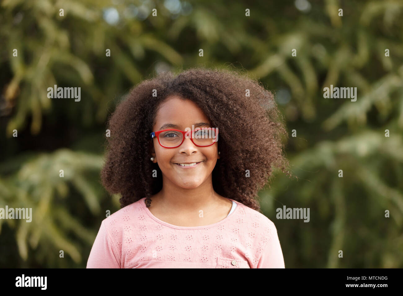 Cute African American girl smiling in the street with afro hair Stock ...