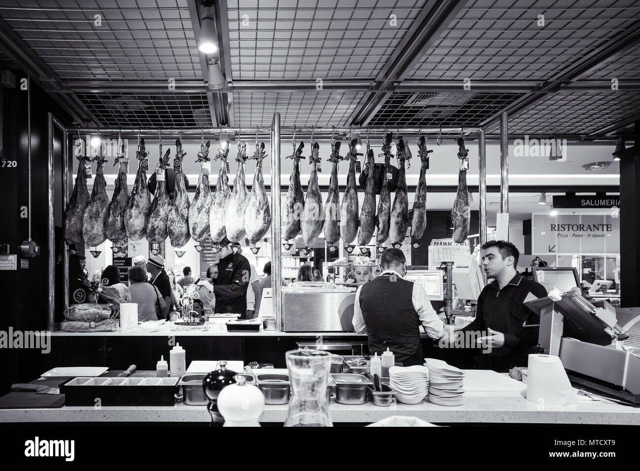 Legs of cured meats hang at one of the many specialty food outlets in