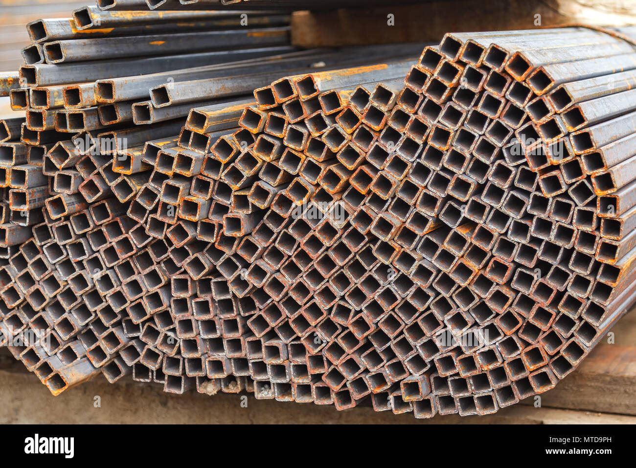 Metal square pipes connected together. The pipes are covered with rust ...