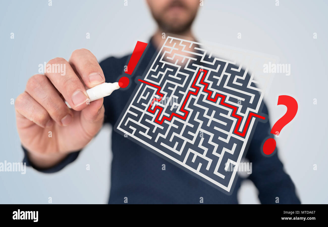 man with pen finding solution to complicated problem concept with maze Stock Photo