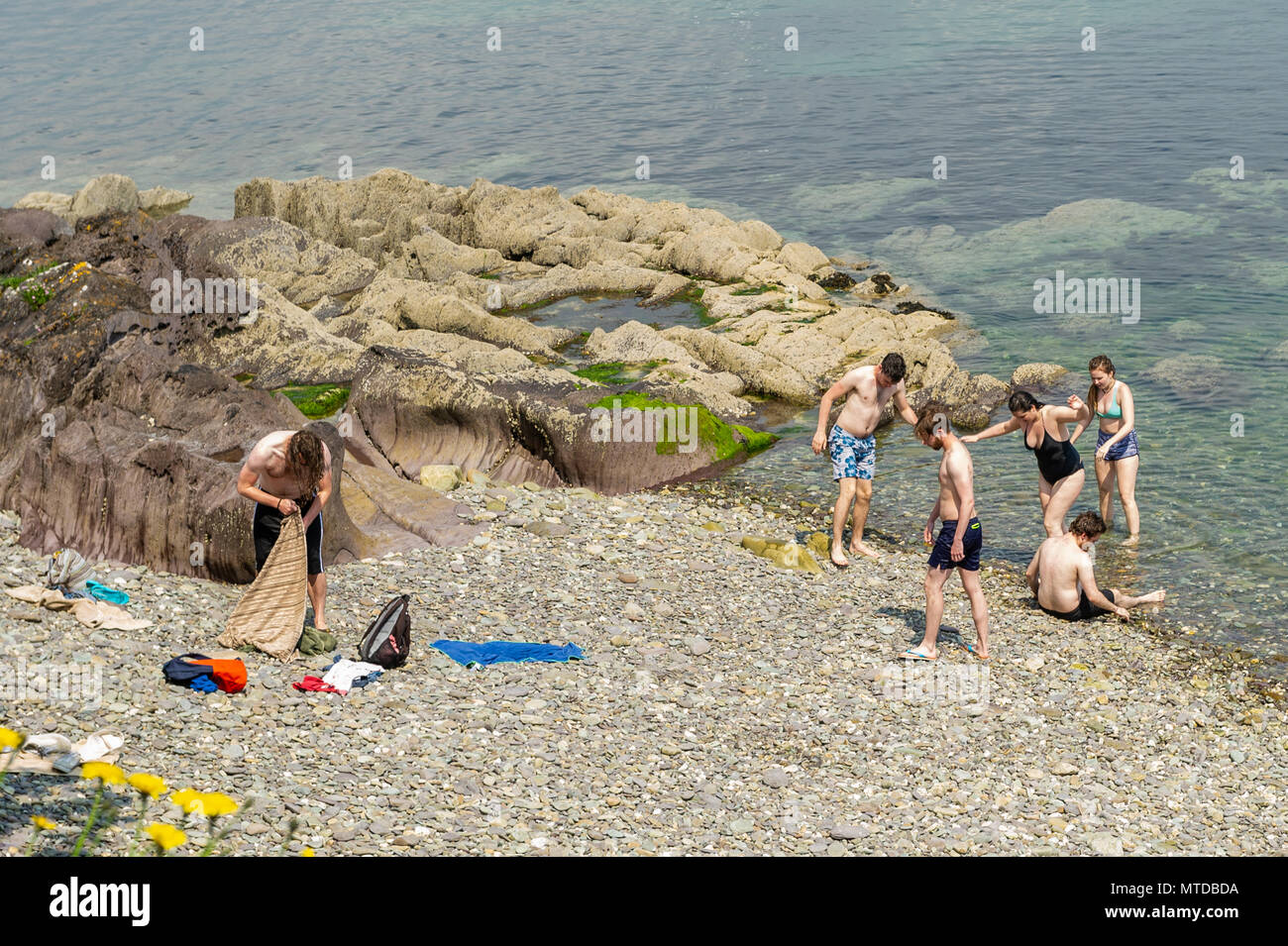 Schull, Ireland. 29th May, 2018.  On the hottest day of the year in West Cork,a group of friends cool off in Schull Harbour. Warm sunshine and highs of up to 27 C will give way to heavy showers and possible thunderstorms later in the day. Credit: Andy Gibson/Alamy Live News. Stock Photo