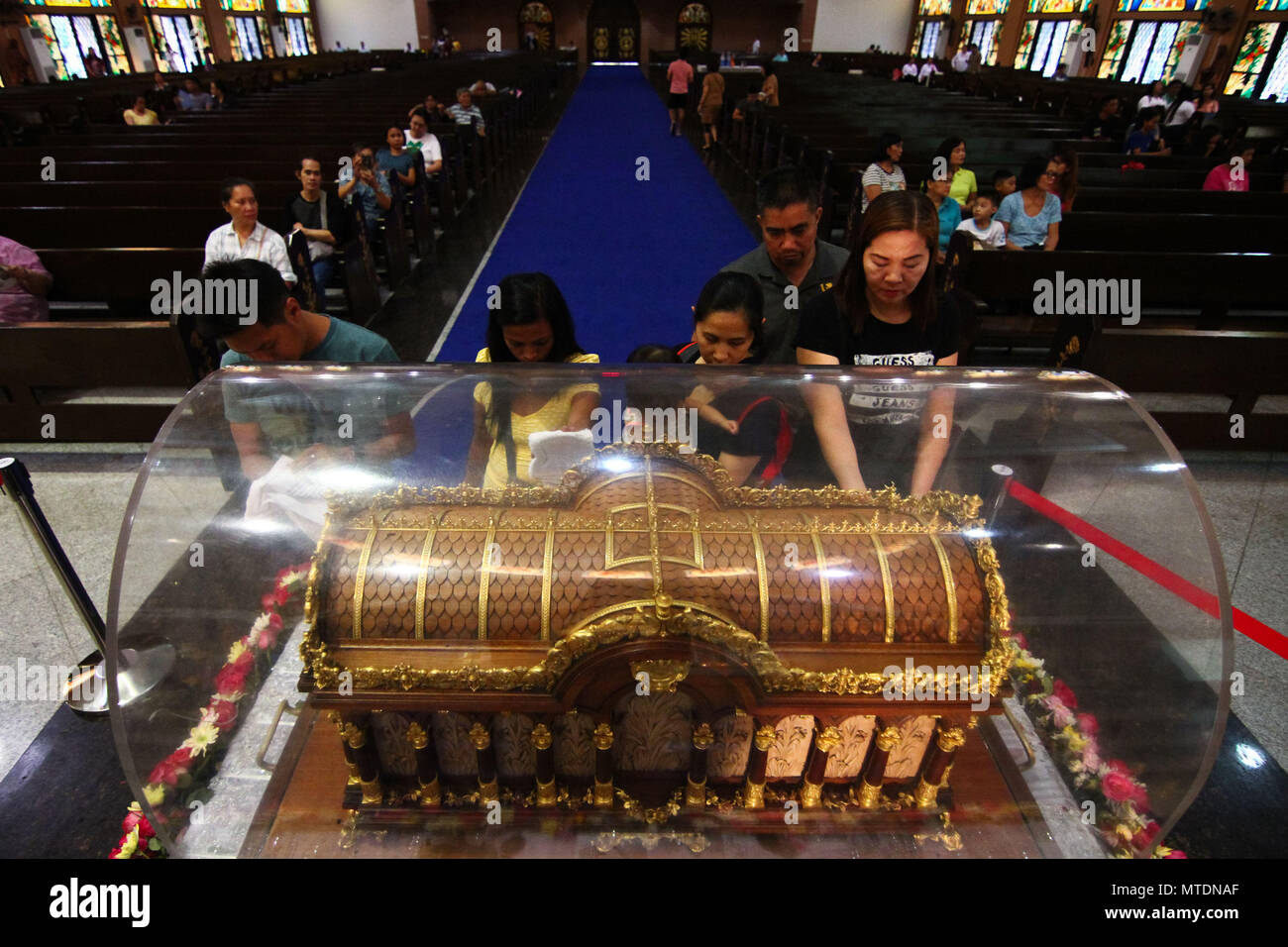 Catholic devotees seen touching the Shrine of Saint Therese of the ...