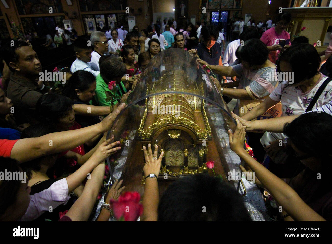 Catholic devotees seen touching the Shrine of Saint Therese of the ...