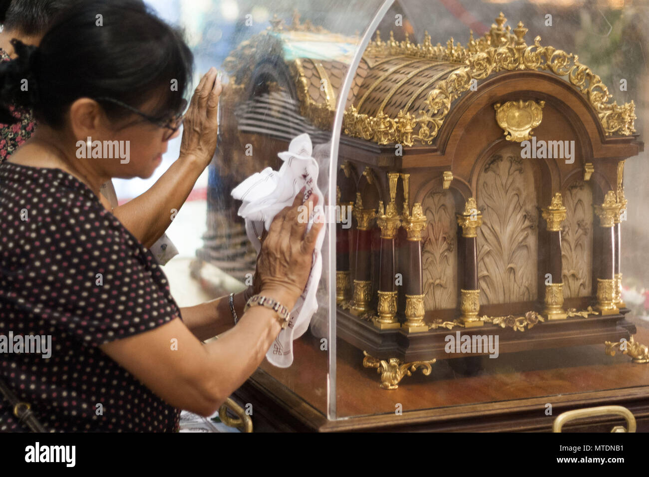Catholic devotees seen touching the Shrine of Saint Therese of the
