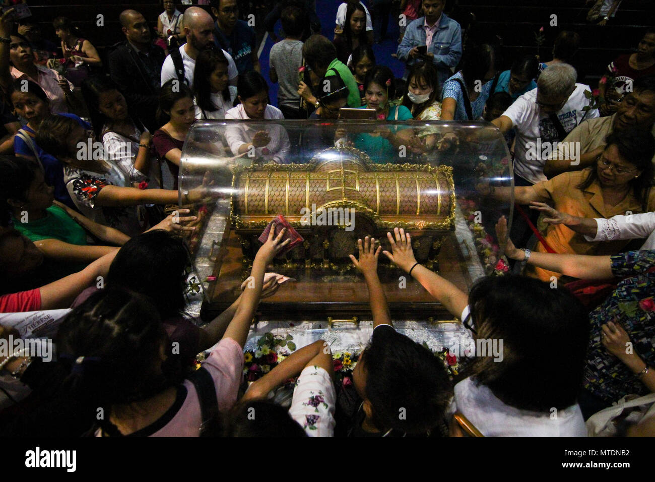 Catholic devotees seen touching the Shrine of Saint Therese of the ...