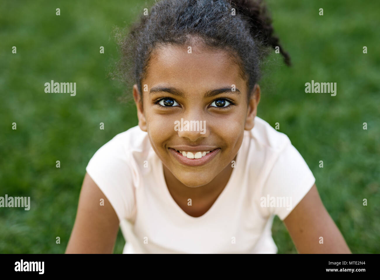 Close up portrait of cute smiling girl, sitting on grass Stock Photo ...