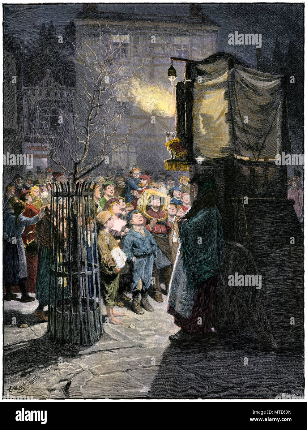 Children watching a Punch and Judy show on a London street, 1800s. Hand-colored woodcut Stock Photo