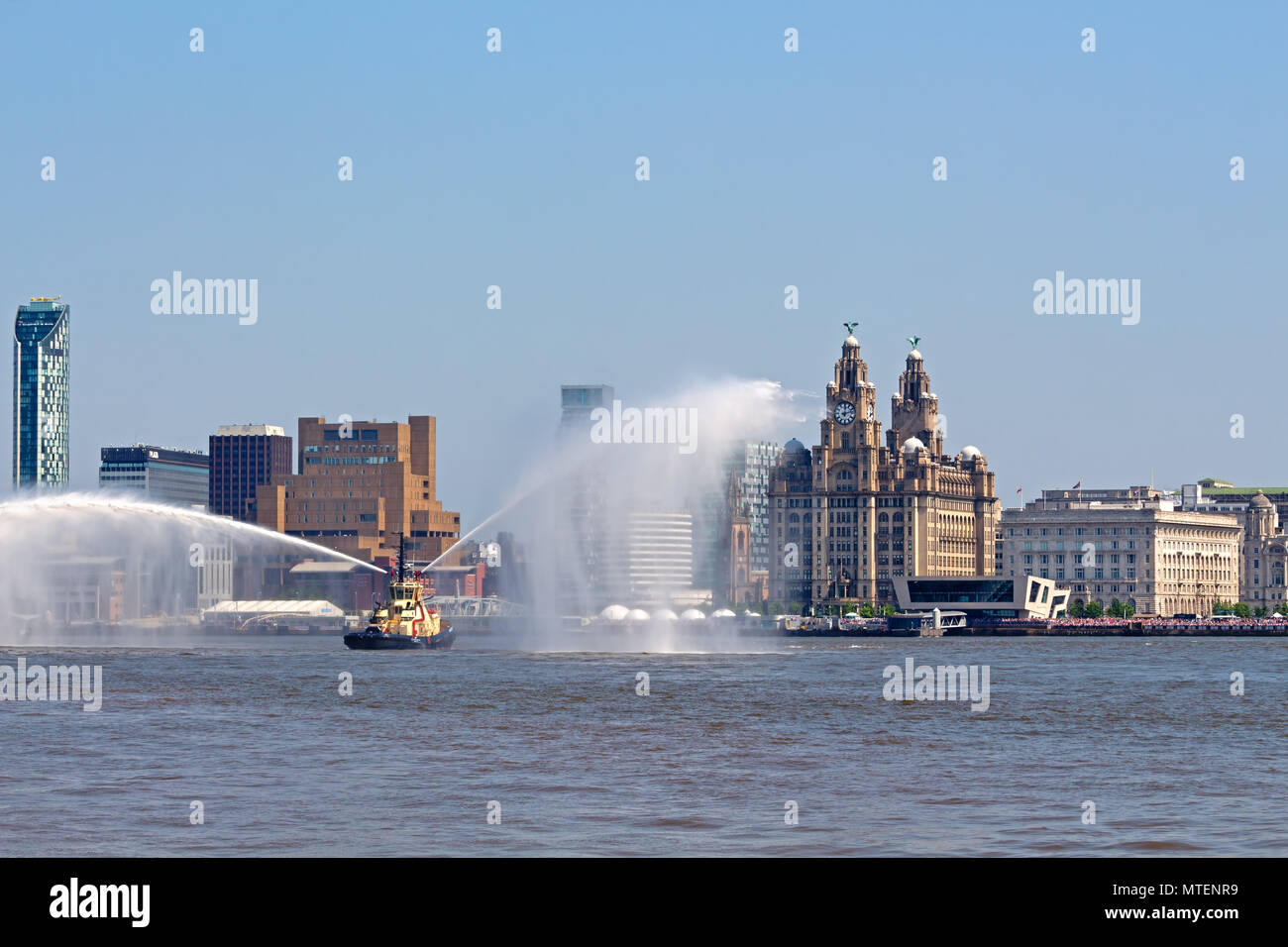 The Tug Svitzer Bidston puts on a display in front of the Liver Buildings at the Tall Ships Festival on the River Mersey in May 2018 Stock Photo