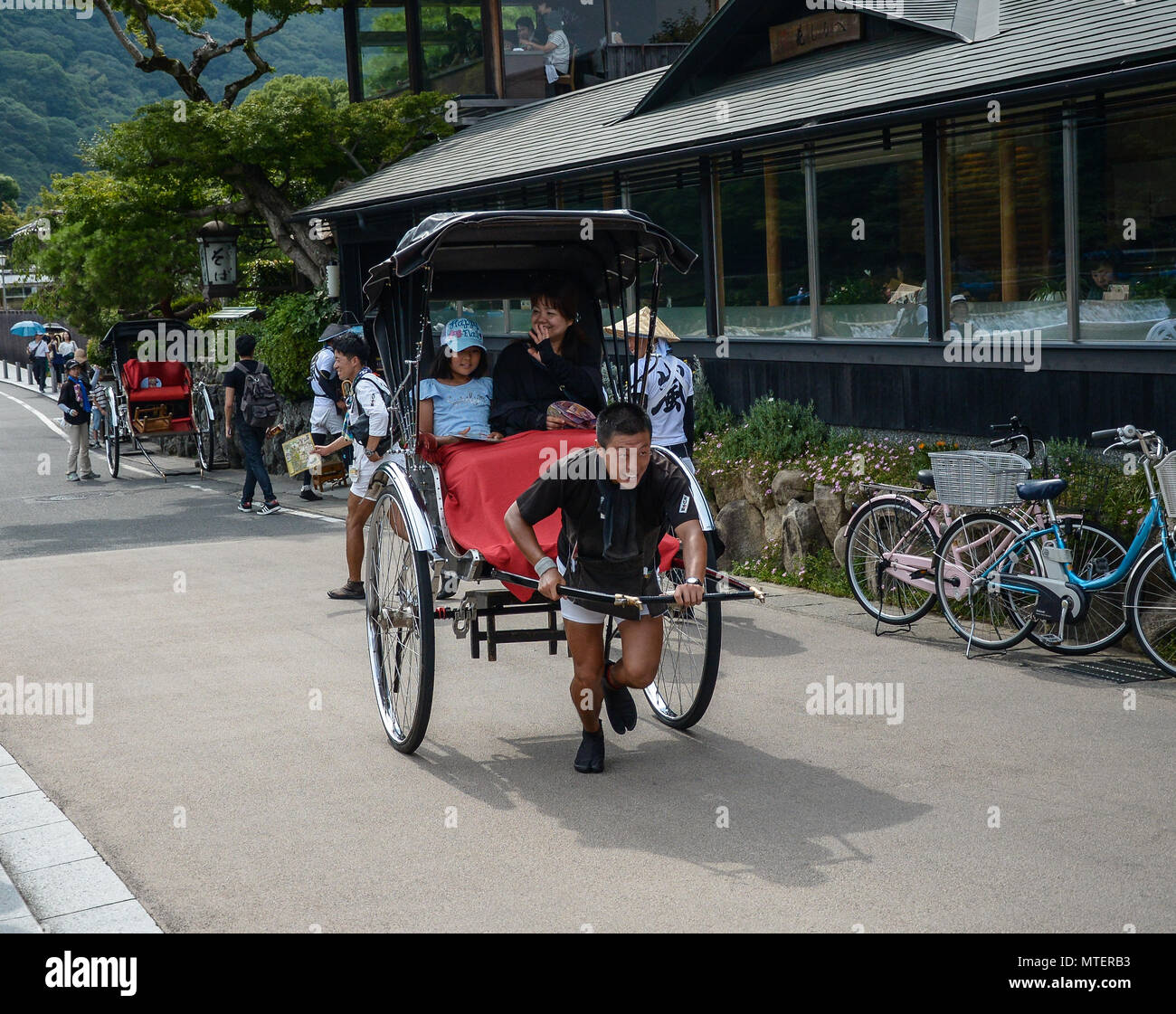 Kyoto, Japan - 24 July 2016. Tourists rides a rickshaw at Arashiyama ...