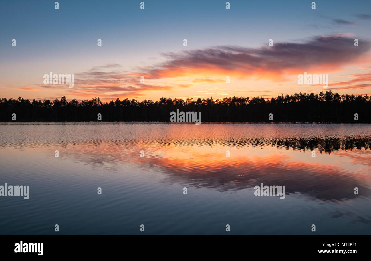 Scenic lake view with reflections and sunset at peaceful evening in National Park Finland Stock Photo