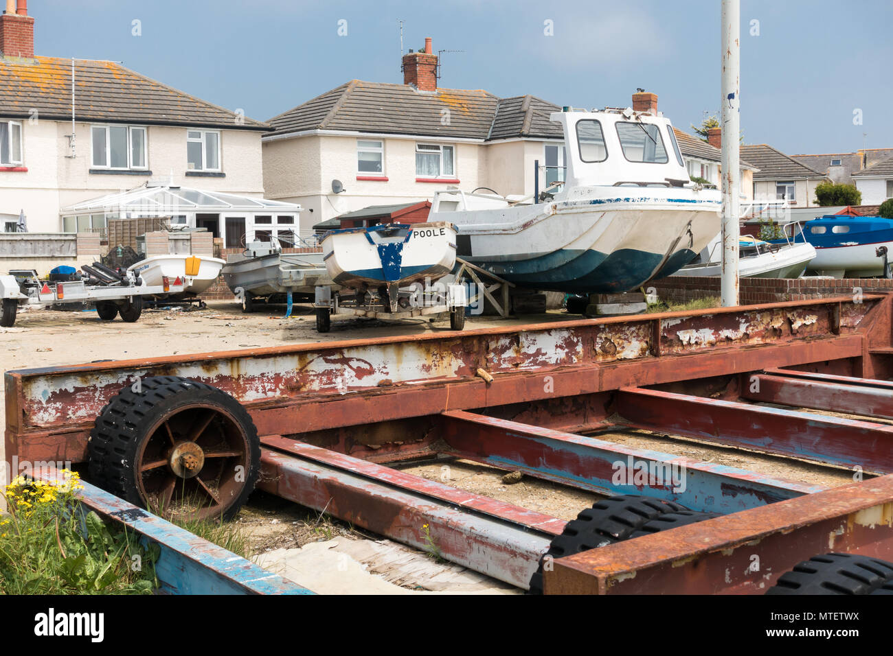 Boats in a yard behind some houses in Poole, Dorset, United Kingdom Stock Photo