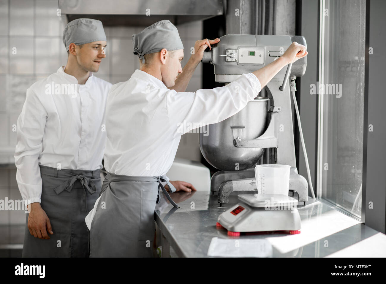 Confectioners working with kneader machine at the bakery manufacturing Stock Photo Alamy