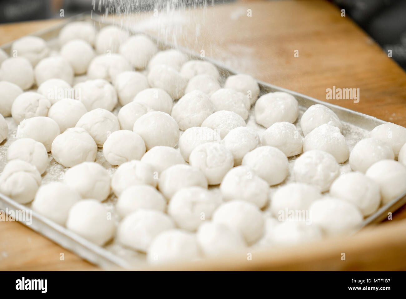 Close-up view on the raw daugh balls ready for baking buns on the tray Stock Photo