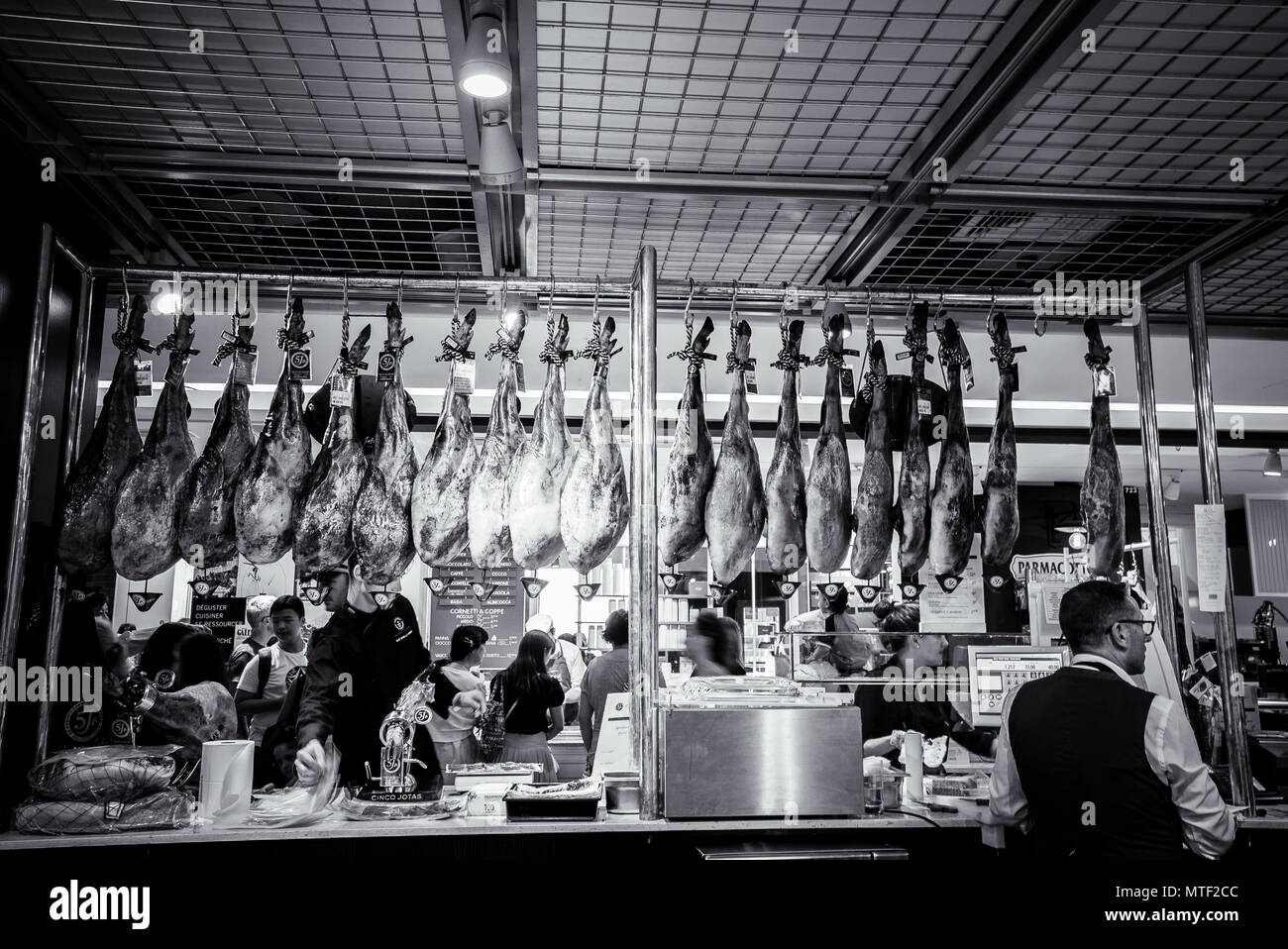 Legs of cured meats hang at one of the many specialty food outlets in