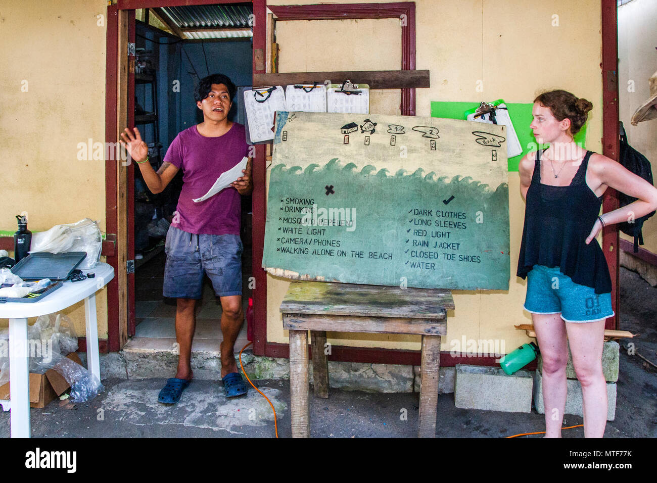 Lecture at Biosphere citizen science project for sea turtles protection in Costa Rica. The rules on the beach are binding and fit on a blackboard. Scientist Fabian Carrosco and Research Assistant Grace Kibblewhite giving the introductory talk Stock Photo