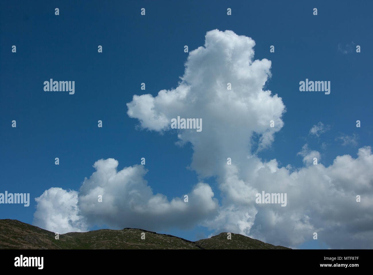Cumulus clouds in blue sky above fells in the Lake District, Cumbria ...