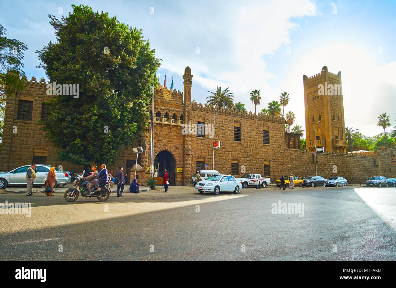 CAIRO, EGYPT - DECEMBER 24, 2017:  The facade of Manial Palace complex with the gate, Moroccan clock tower - minaret and stone wall, serving as a fenc Stock Photo