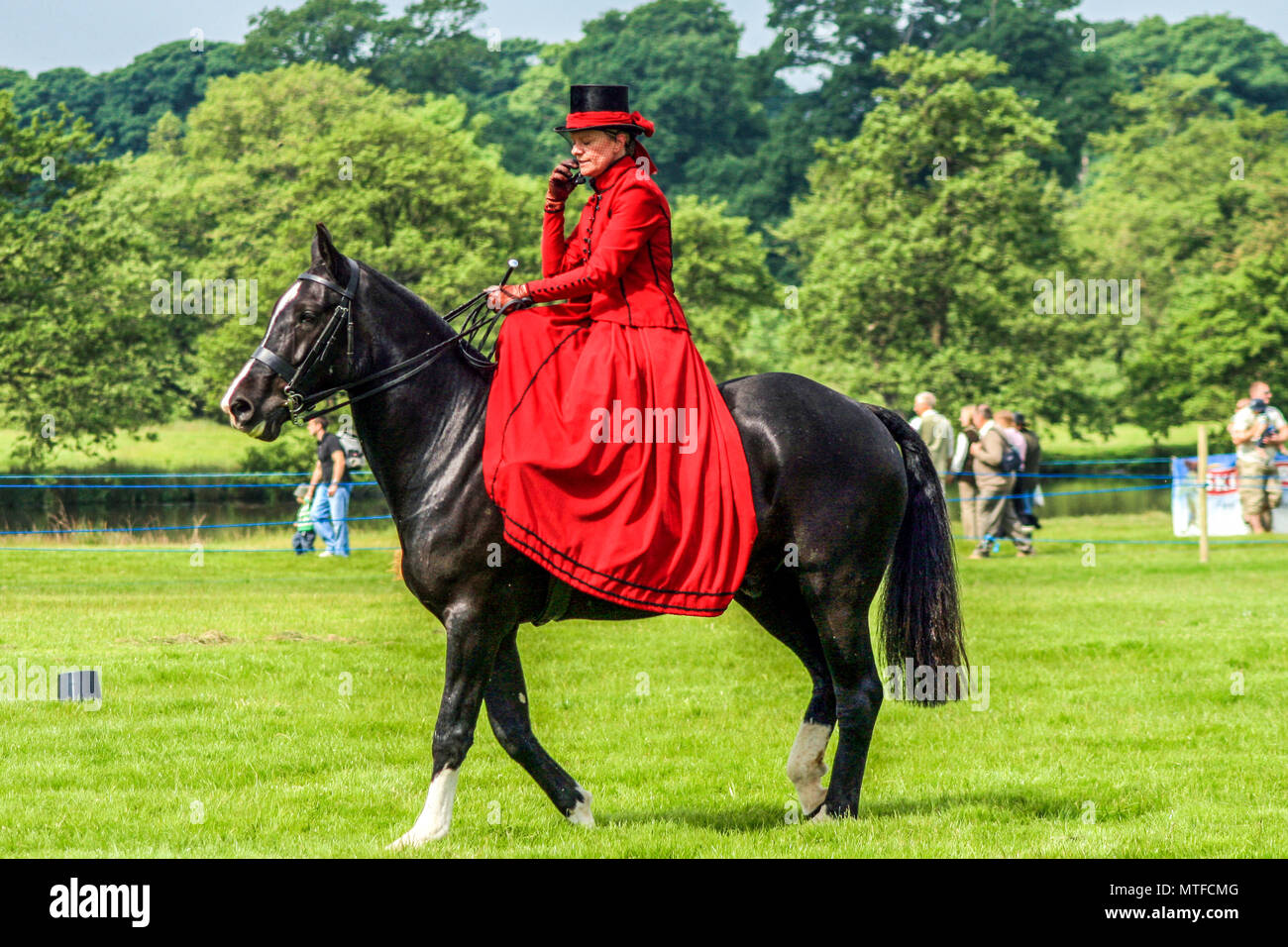 Lady at country and game show demonstrating how to ride a horse side