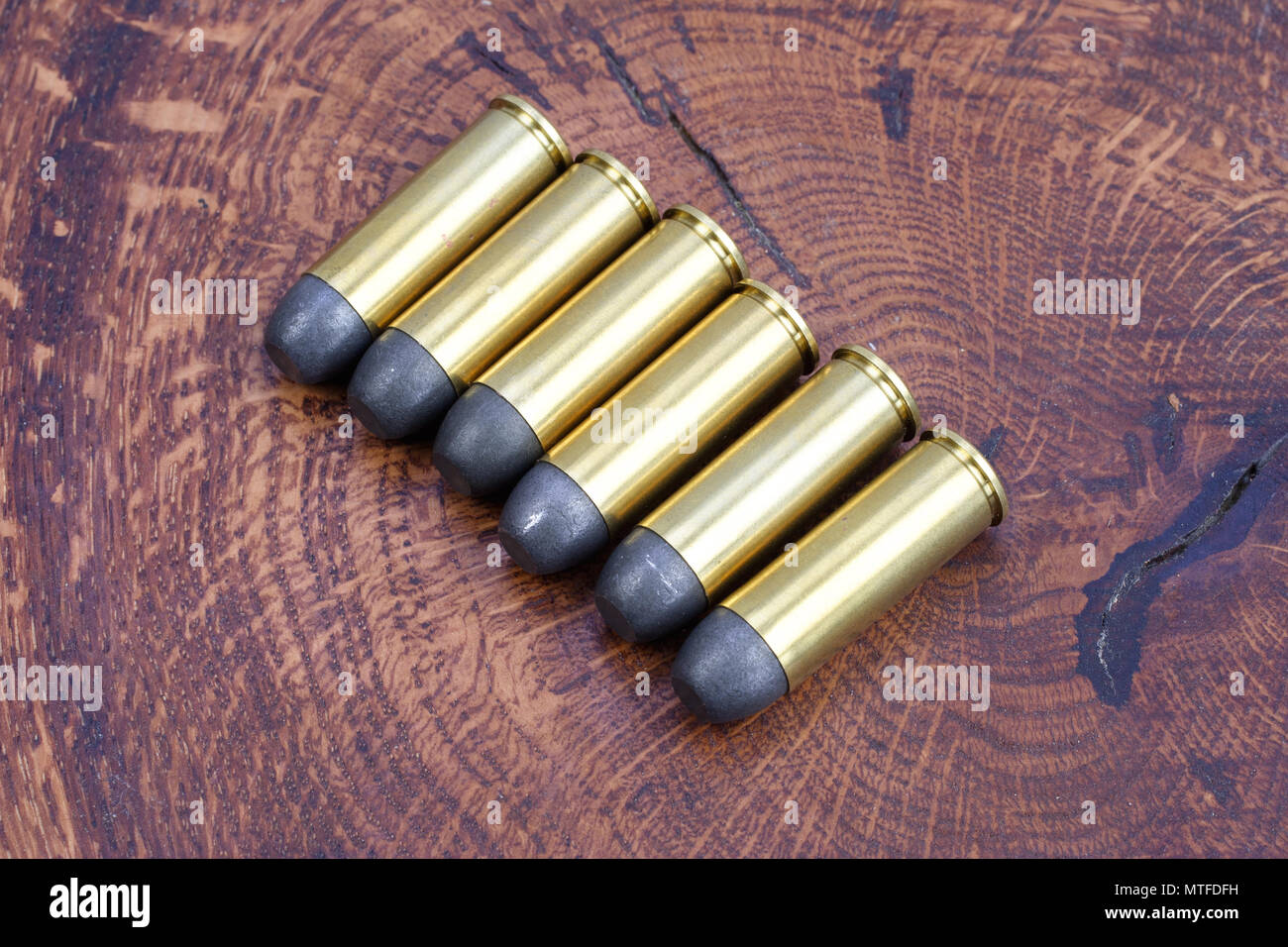 Revolver cartridges .45 Cal Wild West period on wooden background Stock Photo