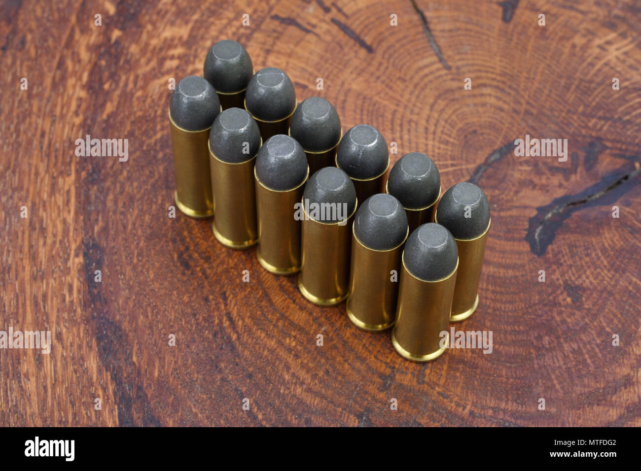 Revolver cartridges .45 Cal Wild West period on wooden background Stock Photo