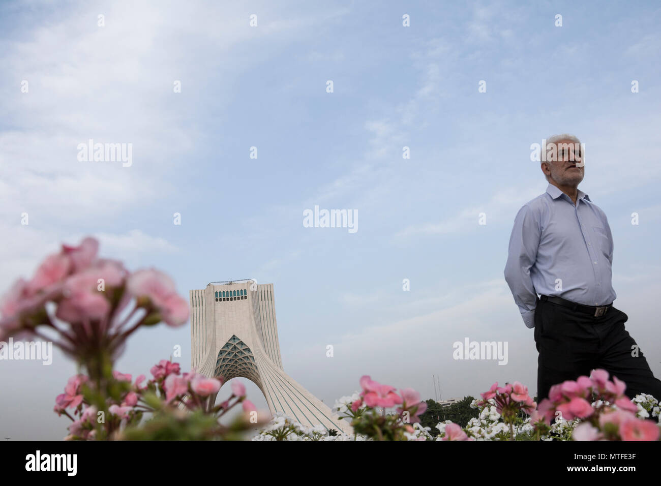 TEHRAN, IRAN - 7 May  2018 The Azadi Tower behind pink and white geranium cranesbill flowers, spring season people enjoying from visiting Stock Photo