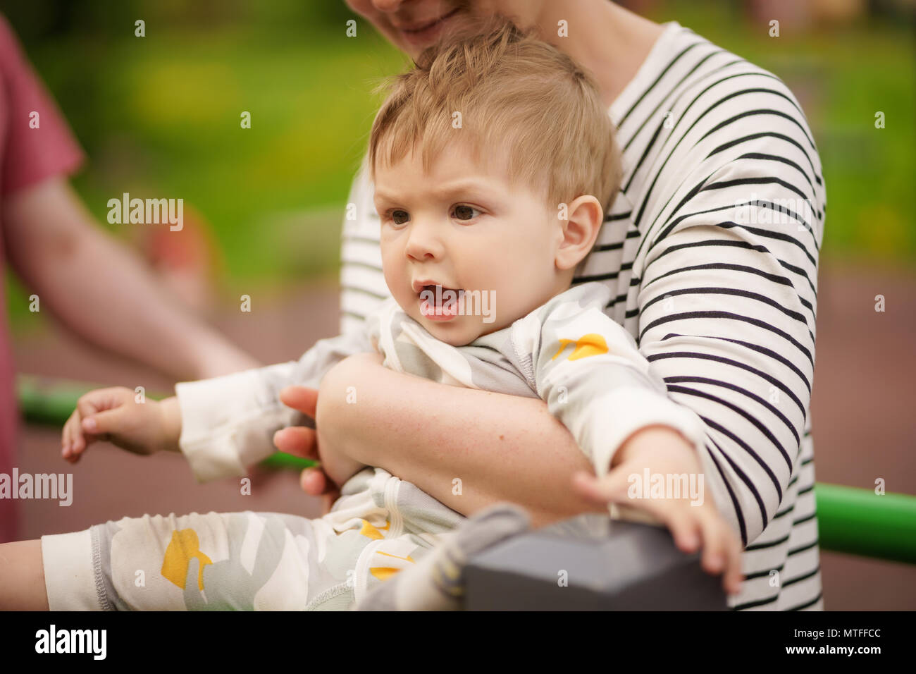 Concept: family values. Portrait of adorable innocent funny brown-eyed baby smiling and playing with his mother. Stock Photo