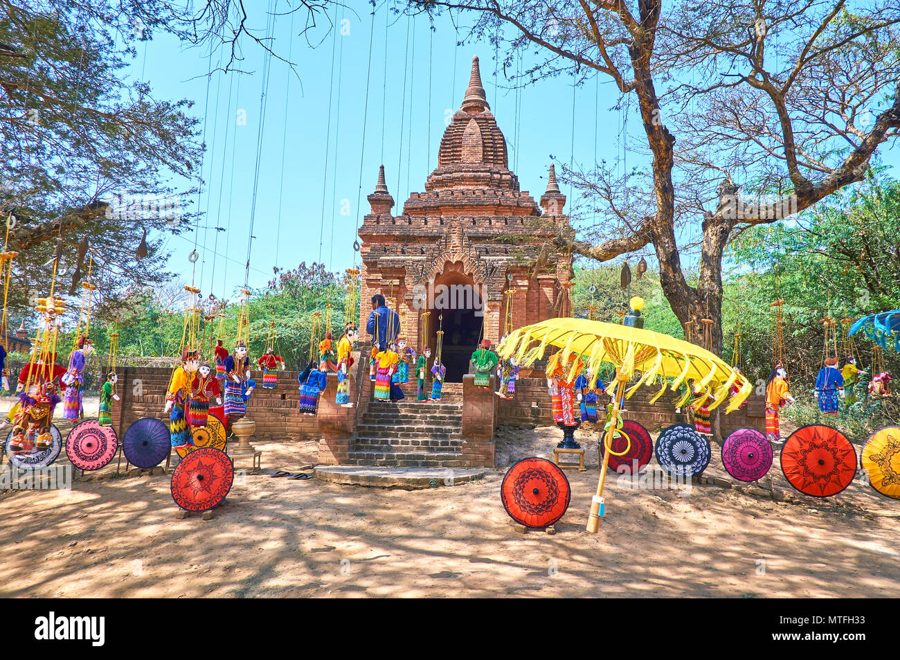 Myanmar beautiful handcrafted umbrellas and hanged puppets attracts tourists to toy exhibition market next to ancient shrines in Bagan Stock Photo