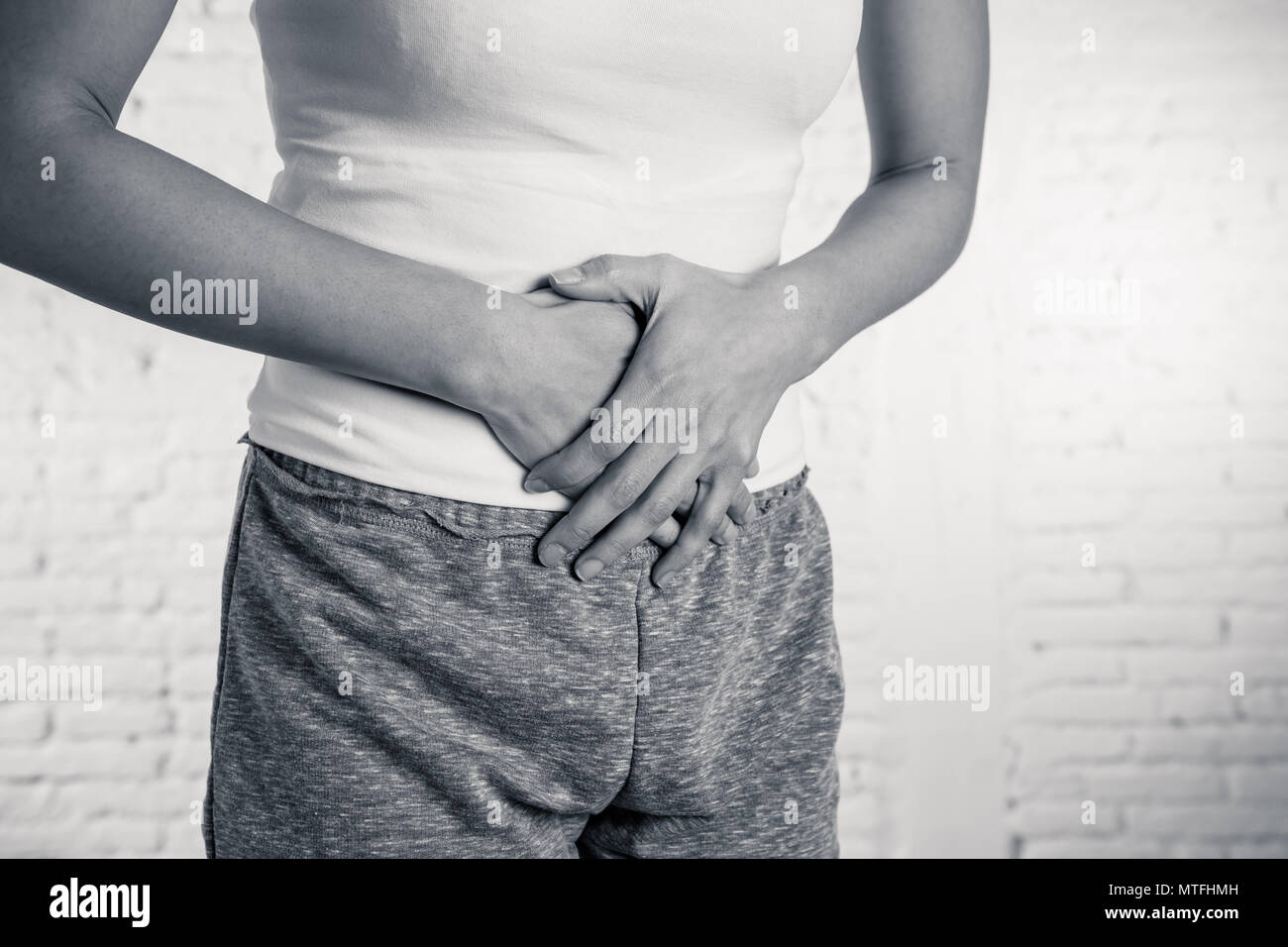 Premium Photo  Woman suffering from stomach pain. young woman with hands  holding her crotch lower abdomen gray