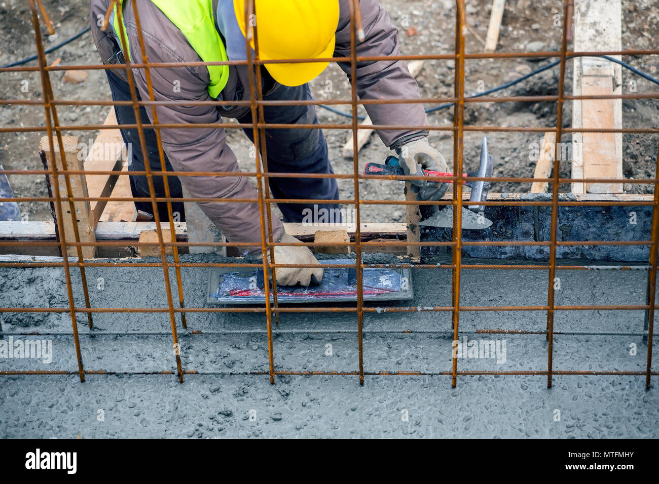 Builder using finishing trowel to leveling and smooth wet concrete