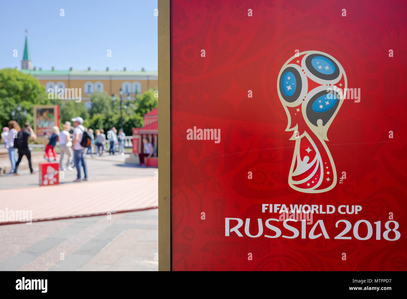 MOSCOW, RUSSIA - MAY 26, 2018: Official logo FIFA World Cup 2018 in Russia printed on a red background canvas, at Manezh Square. Walking people, Kreml Stock Photo