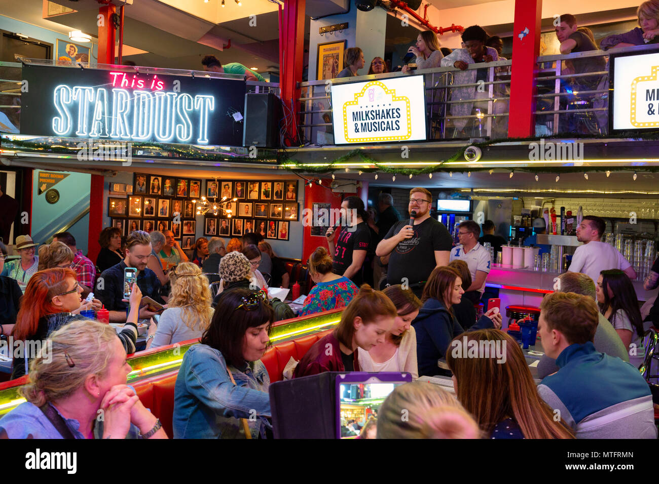 Waiters performing songs from the musicals at Ellens Stardust Diner restaurant, while diners look on, Broadway, New York city USA Stock Photo