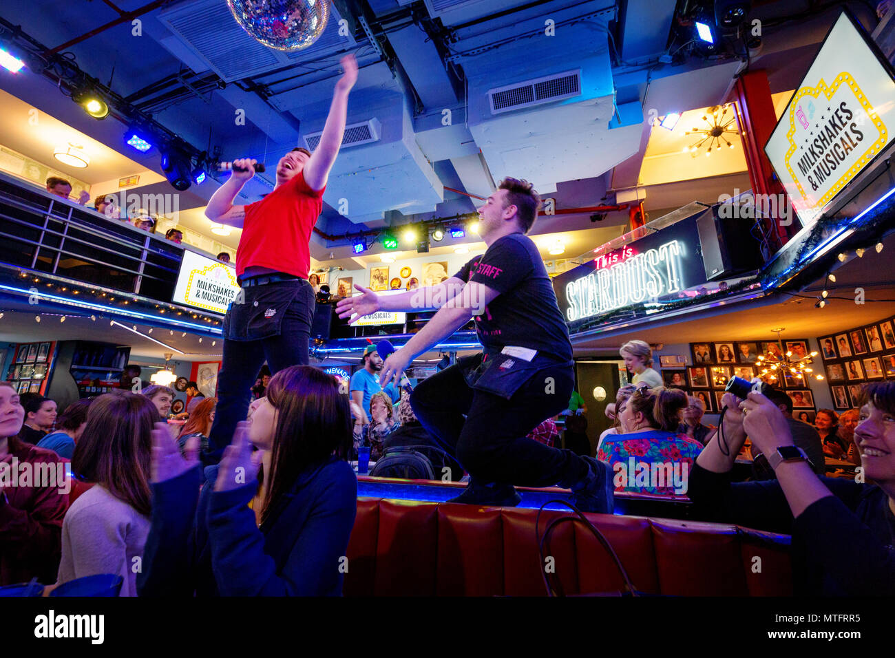 Waiters performing songs from the musicals at Ellens Stardust Diner restaurant, while diners look on, Broadway, New York city USA Stock Photo