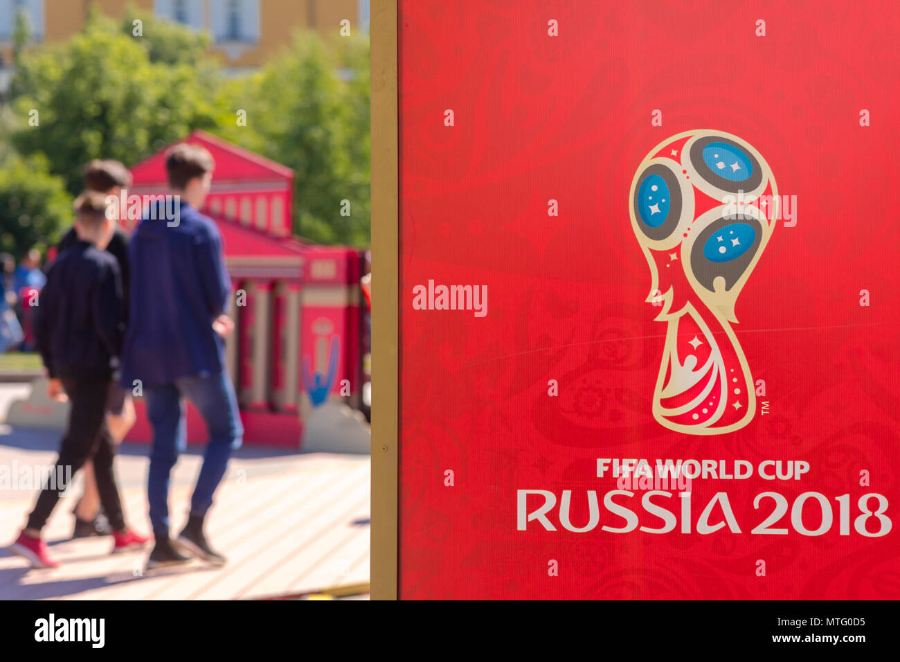 MOSCOW, RUSSIA - MAY 26, 2018: Official logo FIFA World Cup 2018 in Russia printed on a red background canvas, at Manezh Square. Walking people, Kreml Stock Photo