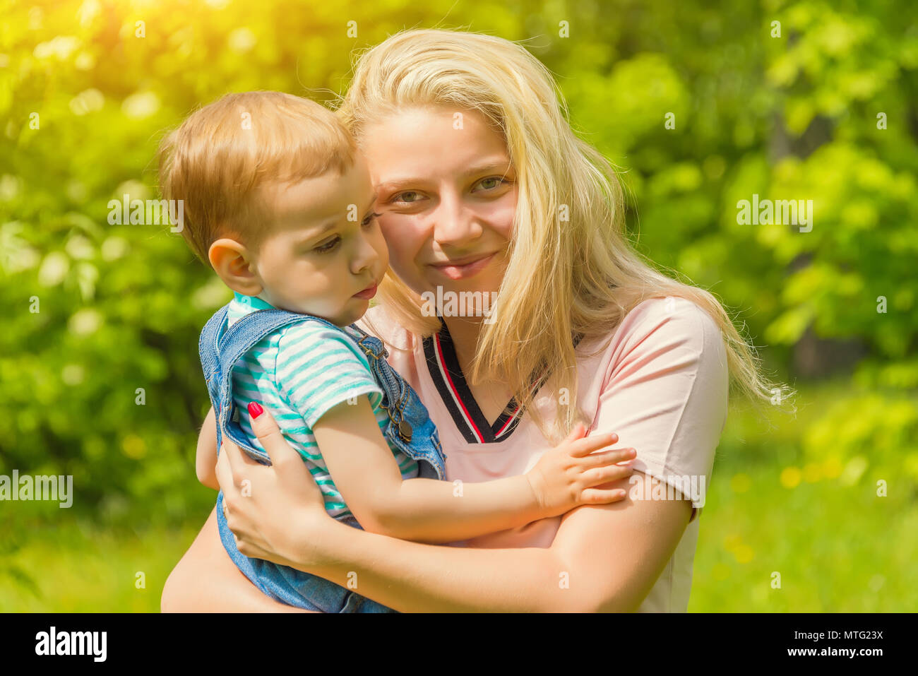 mother and child in nature in the Park, resting on the green grass in ...