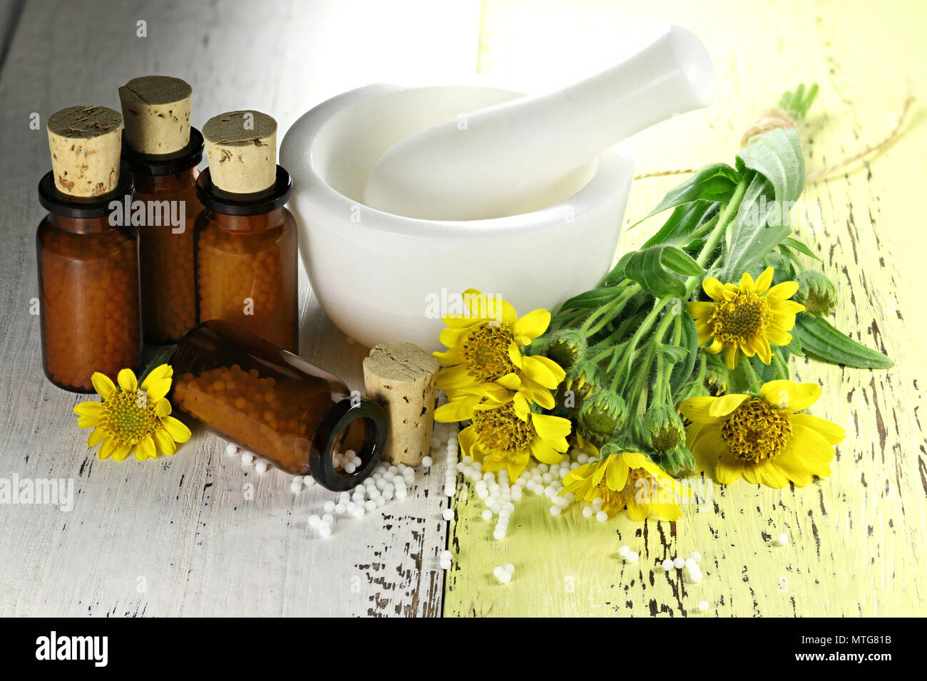 homeopathic arnica pills in brown bottles on wooden background Stock
