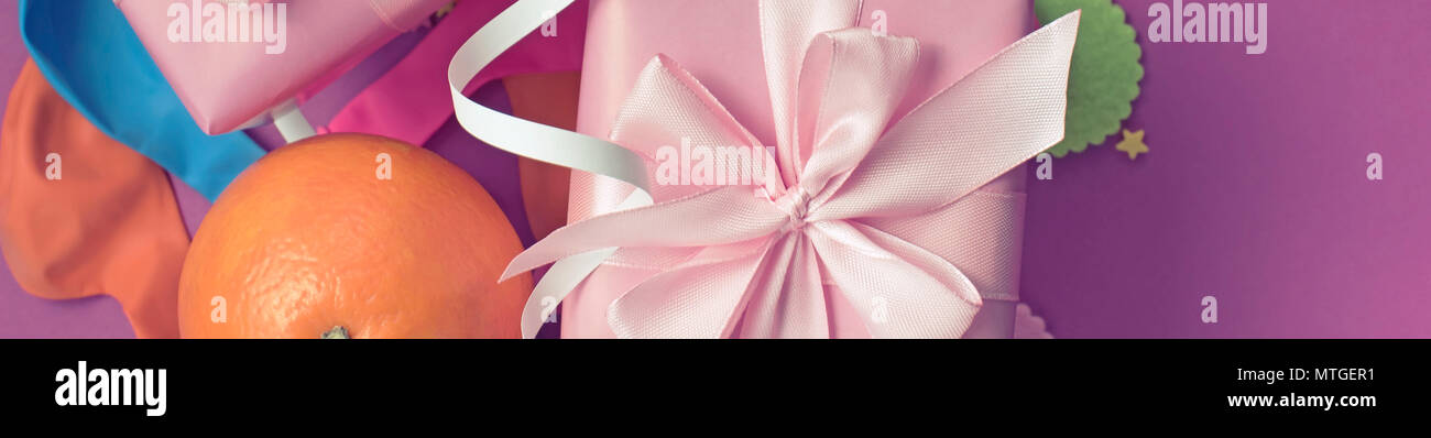 Banner Decorative composition Two boxes with gifts Satin ribbon Bow Oranges Confetti Serpentine birthday party. The view from the top Stock Photo