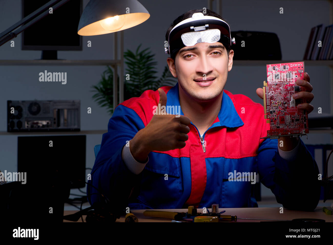 Computer specialist repairing PC late at night Stock Photo - Alamy