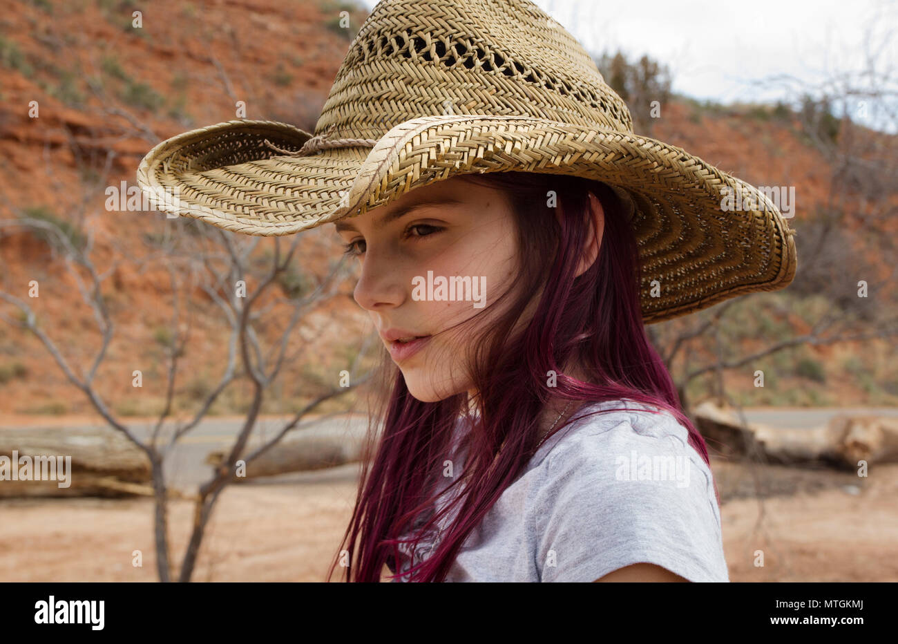 purple dye hair, wearing a cowboy hat 